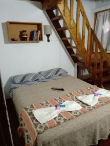 een slaapkamer met een bed en een trap bij Merlo Hostel in Merlo