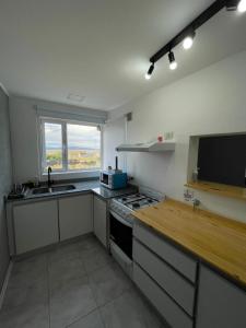 a kitchen with a sink and a stove top oven at Azules 2721 in El Calafate