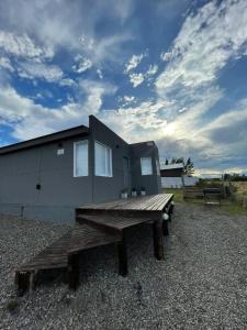 una casa con una mesa de picnic delante de ella en Azules 2721 en El Calafate