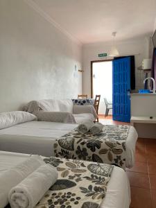 a room with four beds with towels on them at Apartamentos y Habitaciones Villa Marina in La Caleta