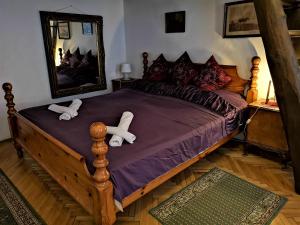 a bedroom with a large wooden bed with two white feet on it at Locomotive Hostel in Budapest