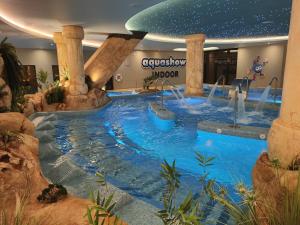 a large indoor pool in a mall with a water park at Aquashow Park Hotel in Quarteira