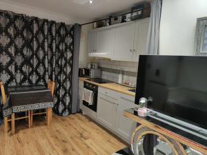 a small kitchen with a television and a table at GRAVESEND - BEAUTIFUL Studio in Kent
