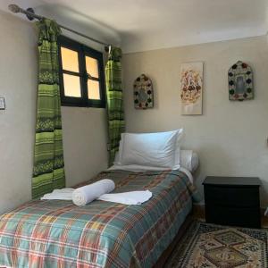 a bedroom with a bed and a window at Auberge Ayam Atlas in Ourika