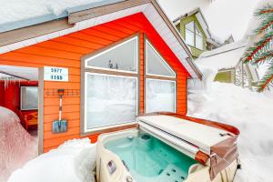 a tiny house with a hot tub in the snow at Snow Pines & Ice and Cozy in Big White