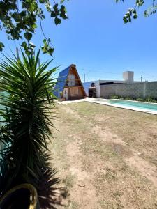 una casa con una palmera frente a un patio en Quinta Las Amapolas en Villa María