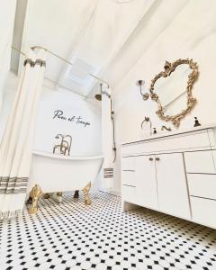 a bathroom with a white tub and a black and white tiled floor at La Villa de Adelina in Ensenada
