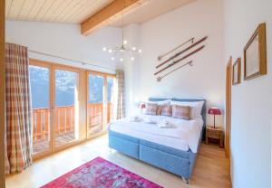 a bedroom with a blue bed and a large window at Racers Retreat 10 in Wengen