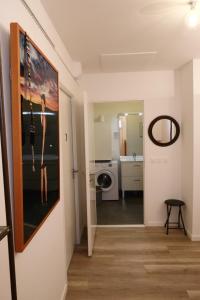 einen Flur, der zu einem Bad mit einer Waschmaschine führt in der Unterkunft Appartement Le Golf in Wimereux