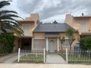 a house with a white fence in front of it at AMANECER in Las Grutas