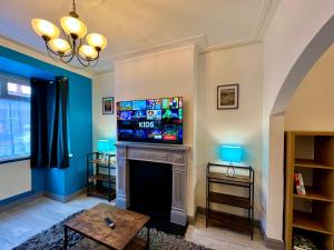 a living room with a fireplace with a tv above it at Bramhall House - Great for Contractors or Family Holidays in Cleethorpes