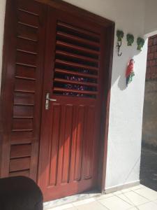 a wooden door with a bunch of wine bottles at Casa Temporada Beberibe in Beberibe