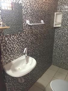 uma casa de banho com um lavatório, um espelho e um WC. em Casa Temporada Beberibe em Beberibe