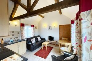 a living room with a couch and a table at New Inn Lane Holiday Cottages in Evesham