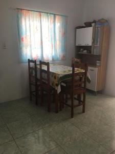 uma mesa de jantar com 2 cadeiras e uma mesa com uma toalha de mesa em Casa Temporada Beberibe em Beberibe