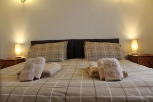 Una cama con toallas y almohadas. en New Inn Lane Holiday Cottages en Evesham