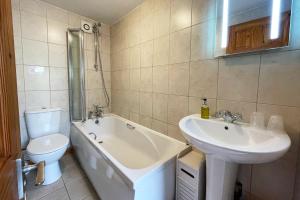 a bathroom with a sink and a tub and a toilet at New Inn Lane Holiday Cottages in Evesham +8 photos