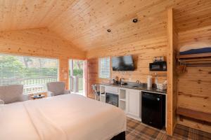 a bedroom with a white bed in a wooden cabin at Carmel River Inn in Carmel