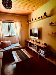 een woonkamer met een bank en een televisie bij Casa Jaguar in Puerto Iguazú
