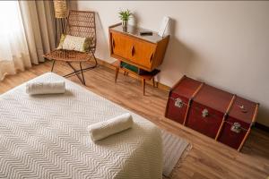 um quarto com uma cama, uma cómoda e uma cadeira em Carvalhal Redondo - Farm House em Castelo Novo