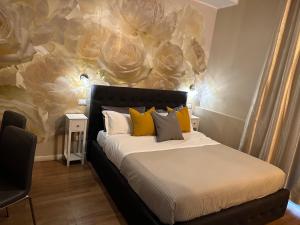 1 dormitorio con 1 cama con pared de flores en Rigoletto Rental Rooms, en Verona