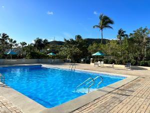 una piscina con acqua blu e palme di Bare Feet Retreat a Frydendal