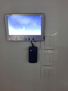 un monitor de ordenador y un ratón sentado en una pared en VILLA NAYFAL en Saly Portudal