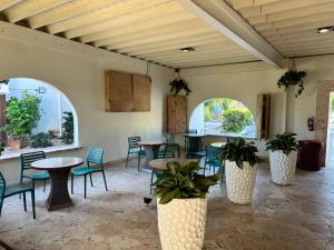a dining room with tables and chairs and plants at Beachfront At Crystal Cove in East End