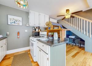 eine Küche mit weißen Schränken und einer Treppe in der Unterkunft Pool Cottage in Gilford