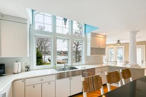 une cuisine avec des placards blancs et une grande fenêtre dans l'établissement Annapolis Bay Ridge Retreat, à Annapolis