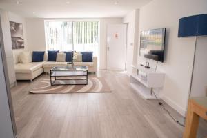 uma sala de estar com um sofá e uma mesa em Maisy Lodge - Two Bed Lux Flat - Parking, Netflix, WIFI - Close to Blenheim Palace & Oxford - F2 em Kidlington