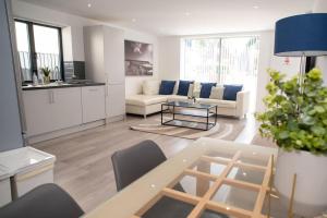 ein Wohnzimmer mit einem Sofa und einem Tisch in der Unterkunft Maisy Lodge - Two Bed Lux Flat - Parking, Netflix, WIFI - Close to Blenheim Palace & Oxford - F2 in Kidlington