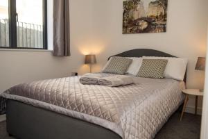 a bedroom with a large bed with two pillows at Maisy Lodge - Two Bed Lux Flat - Parking, Netflix, WIFI - Close to Blenheim Palace & Oxford - F2 in Kidlington