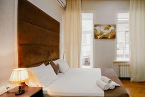 Un dormitorio con una gran cama blanca y una pintura en City Inn Nizami Boutique Hotel en Baku