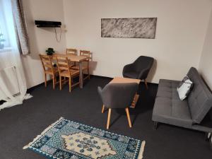 a living room with a couch and a table and chairs at Apartmány Na Cestě in Desná