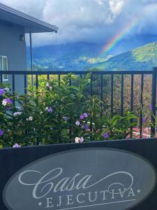 um sinal para um restaurante com um arco-íris ao fundo em Casa Ejecutiva Boquete em Boquete