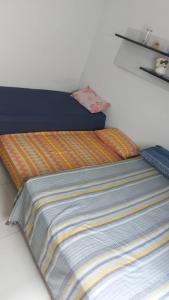 - un lit avec une couverture colorée dans l'établissement Apto Enseada, 2 quadras da praia - 2 quartos com ar condicionado - 6 hospedes, à Guarujá