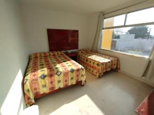1 dormitorio con 2 camas y ventana en Hotel Villa Esmeralda en Cuautla Morelos