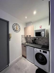 eine Küche mit einer Waschmaschine und einer Mikrowelle in der Unterkunft Luxury Dreams Balneo in Le Cannet