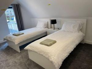two beds sitting next to each other in a bedroom at Orchid Lodge - Two Bed Generous Flat - Parking, Netflix, WIFI - Close to Blenheim Palace & Oxford - F4 in Kidlington