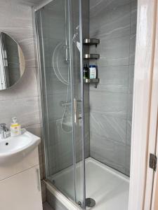 een douche met een glazen deur in de badkamer bij Orchid Lodge - Two Bed Generous Flat - Parking, Netflix, WIFI - Close to Blenheim Palace & Oxford - F4 in Kidlington