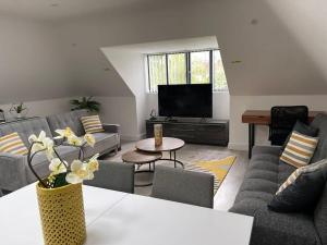 een woonkamer met een bank en een tv bij Orchid Lodge - Two Bed Generous Flat - Parking, Netflix, WIFI - Close to Blenheim Palace & Oxford - F4 in Kidlington