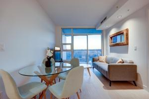 Downtown Properties في فانكوفر: غرفة معيشة مع طاولة وكراسي وأريكة