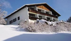 un edificio con nieve en el suelo delante de él en Alpencottage Bad Aussee en Bad Aussee