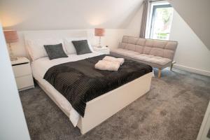 ein Schlafzimmer mit einem großen Bett und einem Sofa in der Unterkunft Rosey Lodge - One Bed Cousy Flat - Parking, Netflix, WIFI - Close to Blenheim Palace & Oxford - F5 in Kidlington