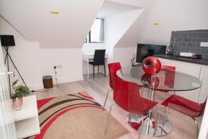 ein Wohnzimmer mit einem Glastisch und roten Stühlen in der Unterkunft Rosey Lodge - One Bed Cousy Flat - Parking, Netflix, WIFI - Close to Blenheim Palace & Oxford - F5 in Kidlington