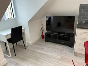 a living room with a desk and a large television at Rosey Lodge - One Bed Cousy Flat - Parking, Netflix, WIFI - Close to Blenheim Palace & Oxford - F5 in Kidlington