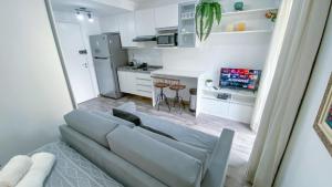 sala de estar con sofá y cocina en Loft Lotus 5 - Lindo Studio na Liberdade, en São Paulo