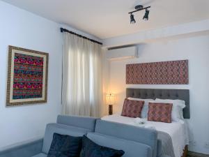 1 dormitorio con sofá azul y cama en Loft Lotus 5 - Lindo Studio na Liberdade, en São Paulo