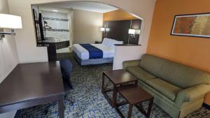 a hotel room with a bed and a couch at SureStay Hotel by Best Western Meridian in Meridian